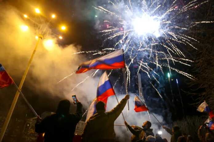Mensen zwaaien met Russische vlaggen ter viering van de erkenning van de onafhankelijkheid in het centrum van Donetsk